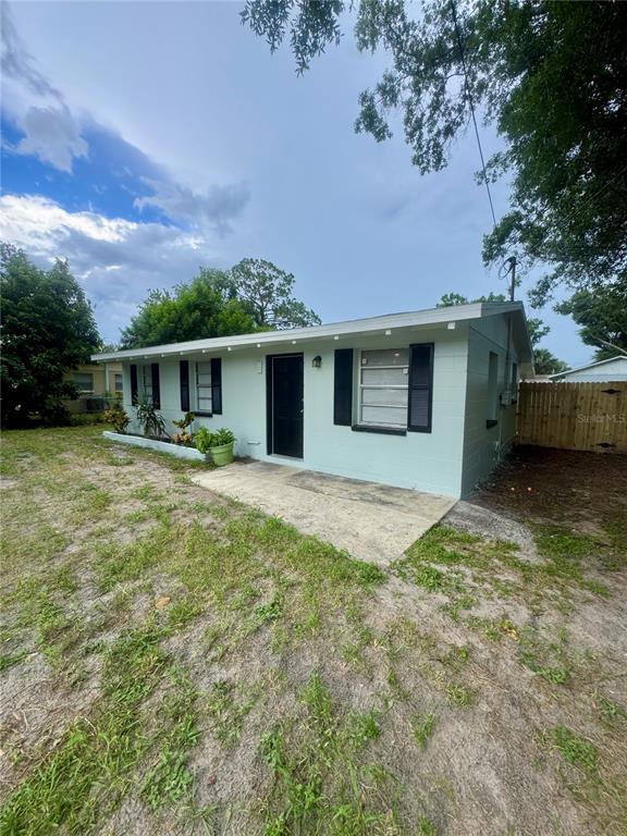 A single-story white house with a black front door and black window shutters — 9216 W PATTERSON STREET, TAMPA, FL