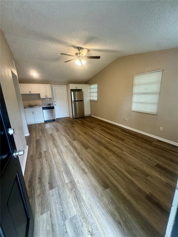 A kitchen and dining area feature white cabinets, stainless steel appliances, and wood-look flooring — 9216 W PATTERSON STREET, TAMPA, FL
