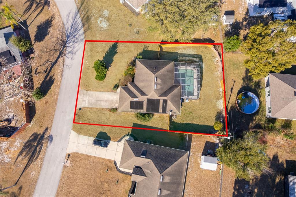 An aerial view shows a house with a pool enclosure and solar panels on the roof — 794 SELBY STREET, DELTONA, FL