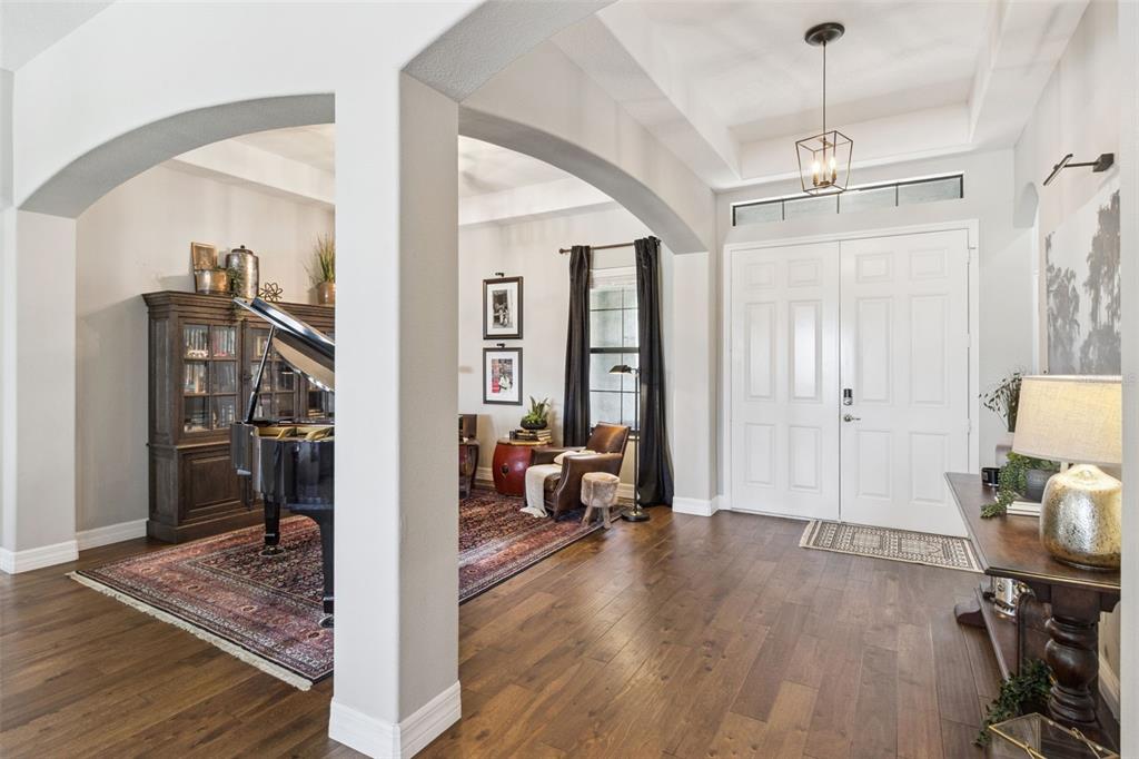 An entryway with hardwood floors, a grand piano, and a double front door — 2590 LAKE MANOR DRIVE, LAND O LAKES, FL