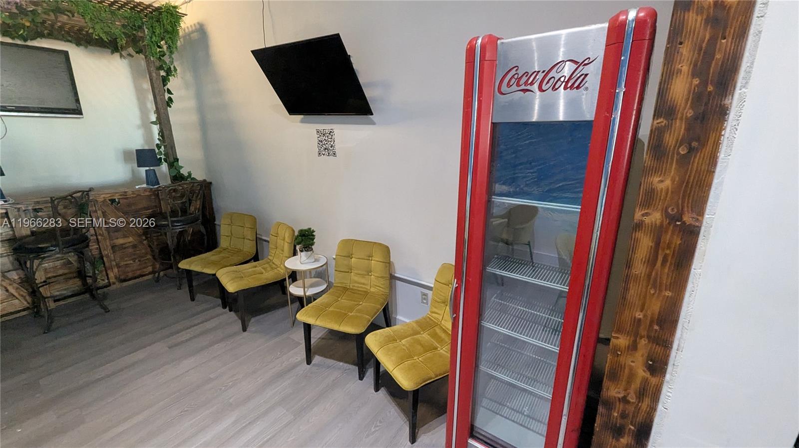 A waiting area features four yellow chairs, a small side table, and a Coca-Cola refrigerator — 1020 71st St # 106, Miami Beach FL 33141, MIAMI BEACH, FL