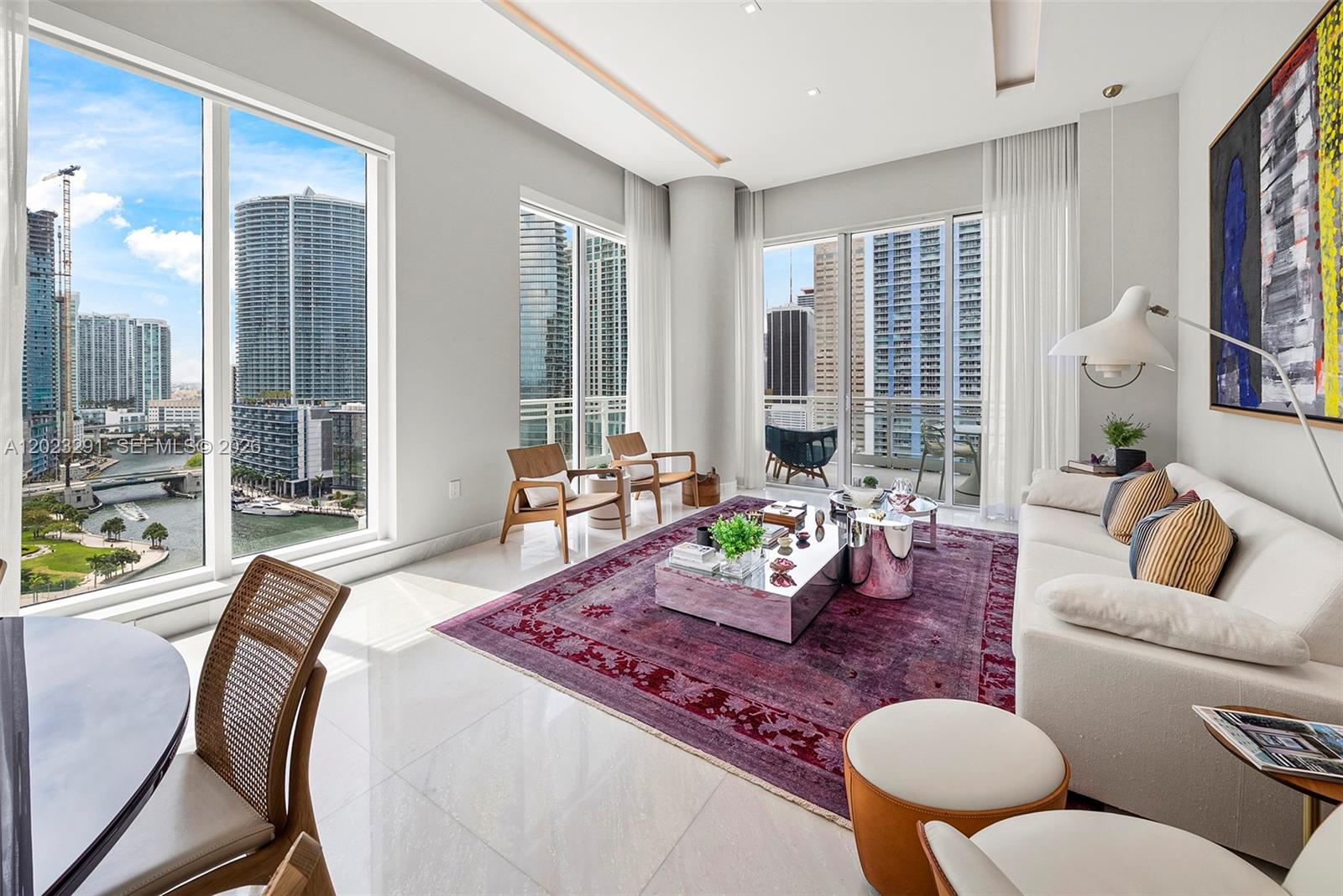 A modern living room features a purple rug, mirrored coffee table, and floor-to-ceiling city views — 900 Brickell Key Blvd # 1801, Miami FL 33131, MIAMI, FL