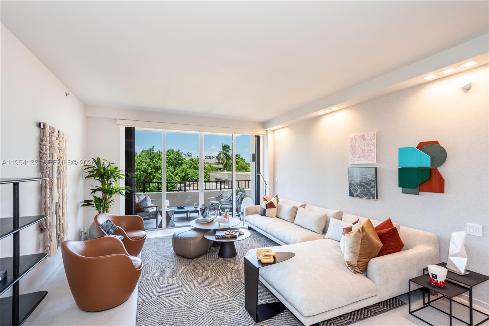 A modern living room features a sectional sofa, two leather chairs, and a balcony view — 251 Crandon Blvd # 306, Key Biscayne FL 33149, KEY BISCAYNE, FL