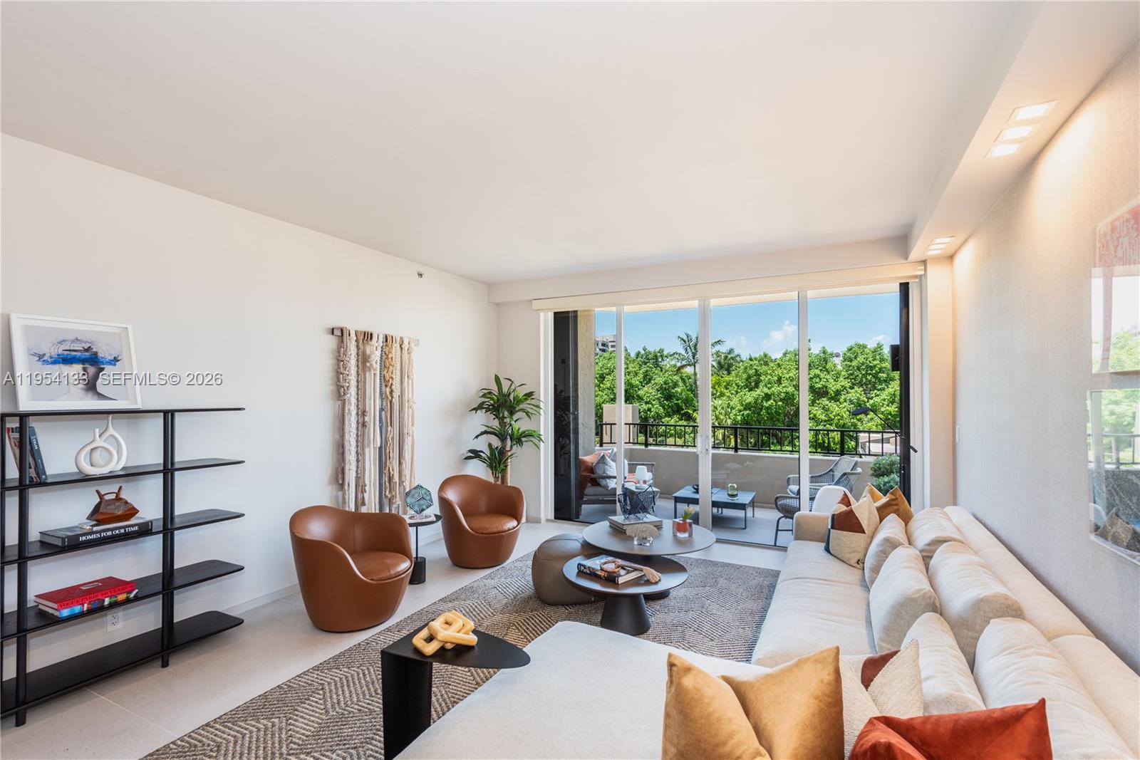 A modern living room features a large sectional sofa, two leather chairs, and a balcony — 251 Crandon Blvd # 306, Key Biscayne FL 33149, KEY BISCAYNE, FL