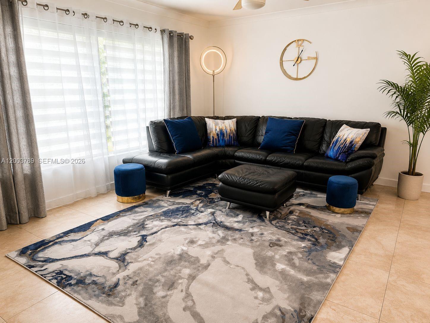 A living room features a black sectional sofa, a patterned area rug, and blue accents — 906 NE 6th St # 0, Hallandale Beach FL 33009, HALLANDALE BEACH, FL
