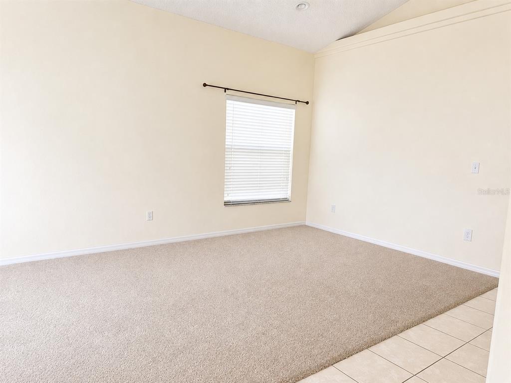 A single-story house with a white garage, arched entryway, and a palm tree in the yard — 16647 FRESH MEADOW DRIVE, CLERMONT, FL