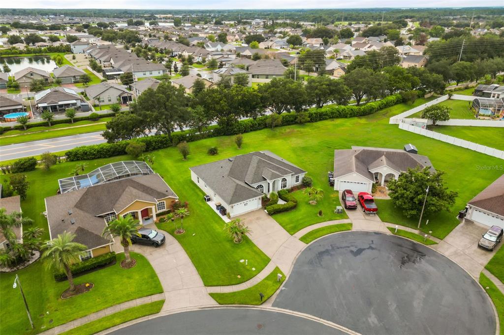 An aerial view shows three suburban houses with driveways and lawns in a residential neighborhood — 3806 OPAL CIRCLE, ST CLOUD, FL
