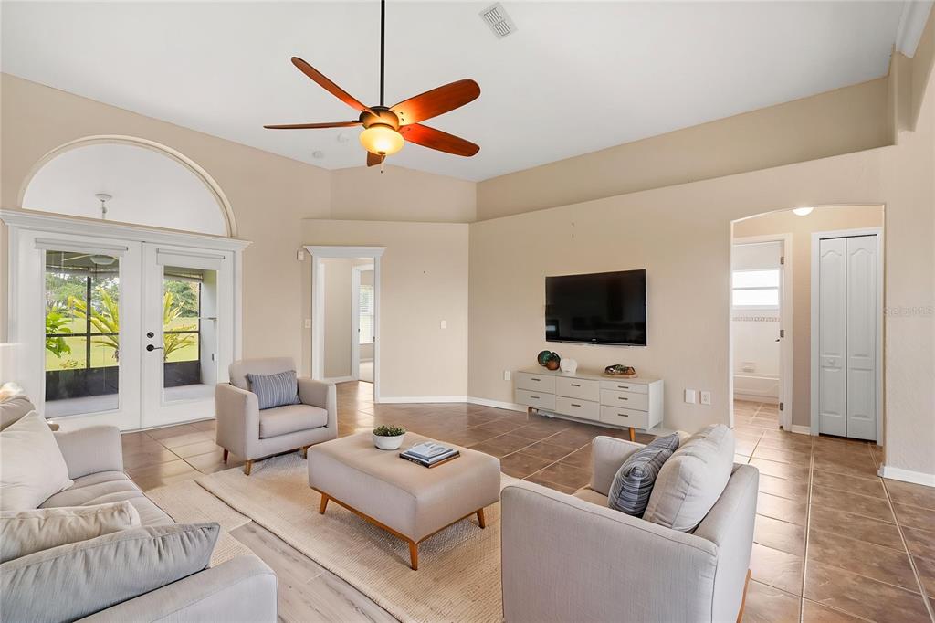 A living room with tile floors, a ceiling fan, and a wall-mounted television — 3806 OPAL CIRCLE, ST CLOUD, FL