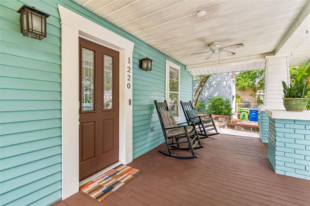 A covered front porch features light blue siding, a brown door, and two rocking chairs — 1220 E EMMA STREET, TAMPA, FL