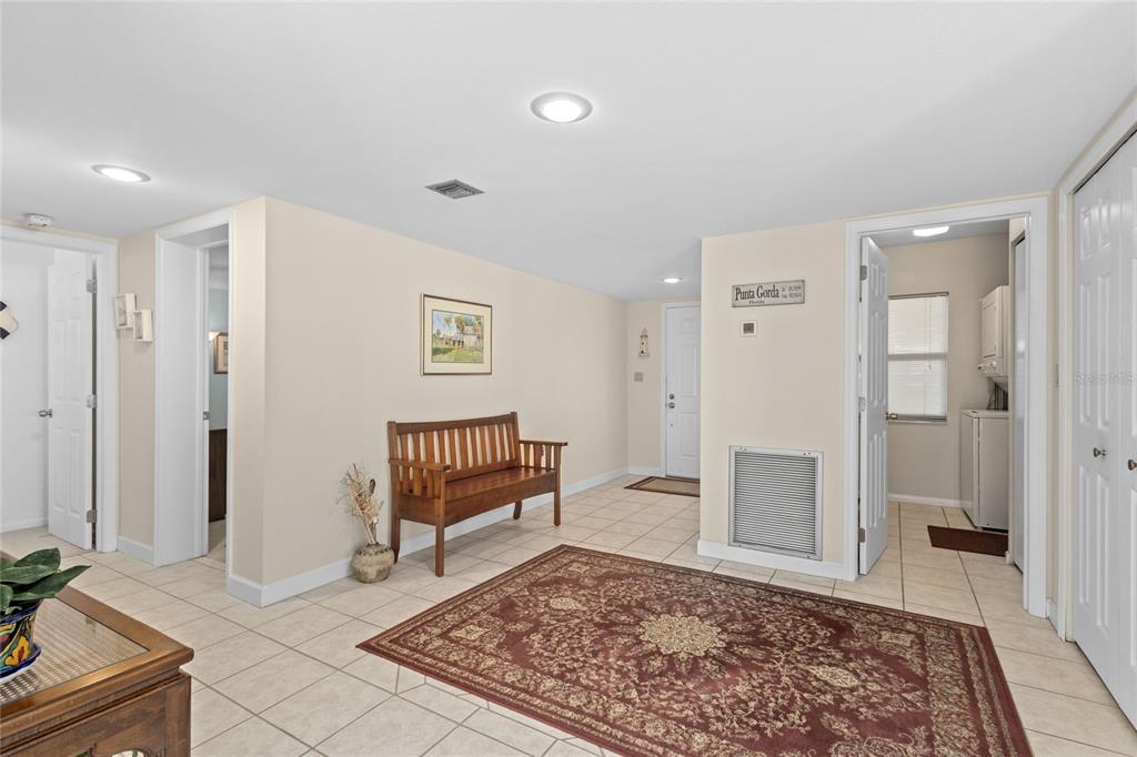 A tiled entryway features a wooden bench, a patterned rug, and multiple doorways — 3230 SOUTHSHORE DRIVE UNIT 36B, PUNTA GORDA, FL