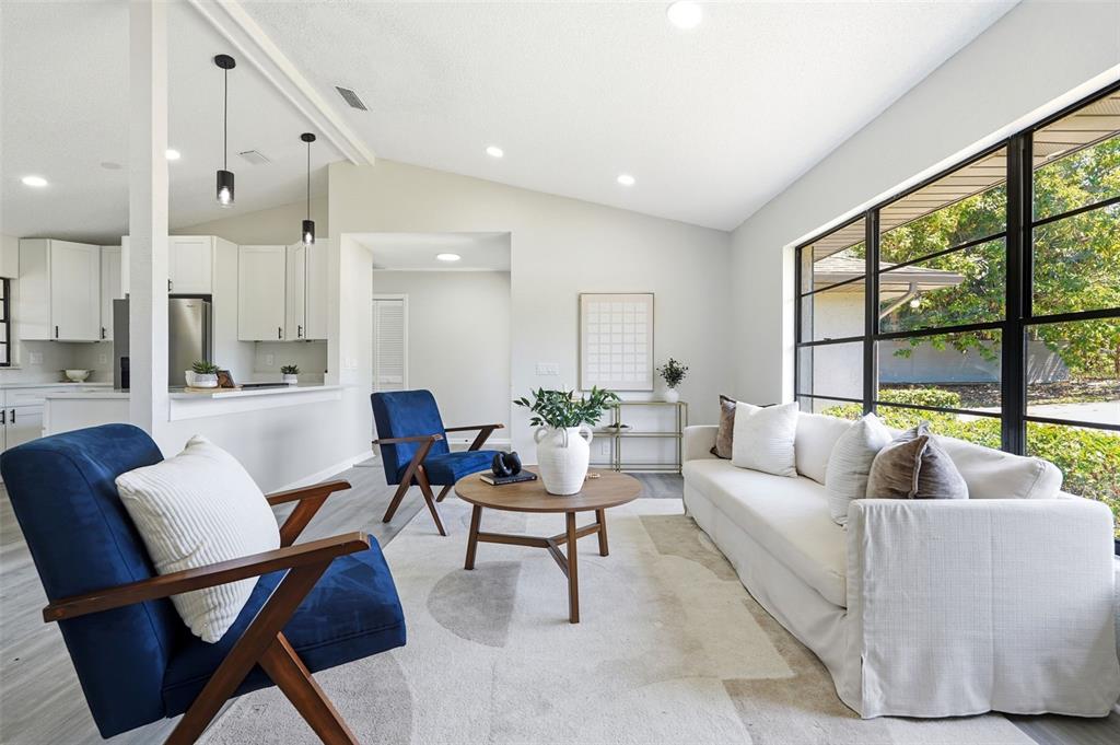 A living room features a white sofa, two blue armchairs, and a round wooden table — 1020 S SCENIC HIGHWAY, LAKE WALES, FL