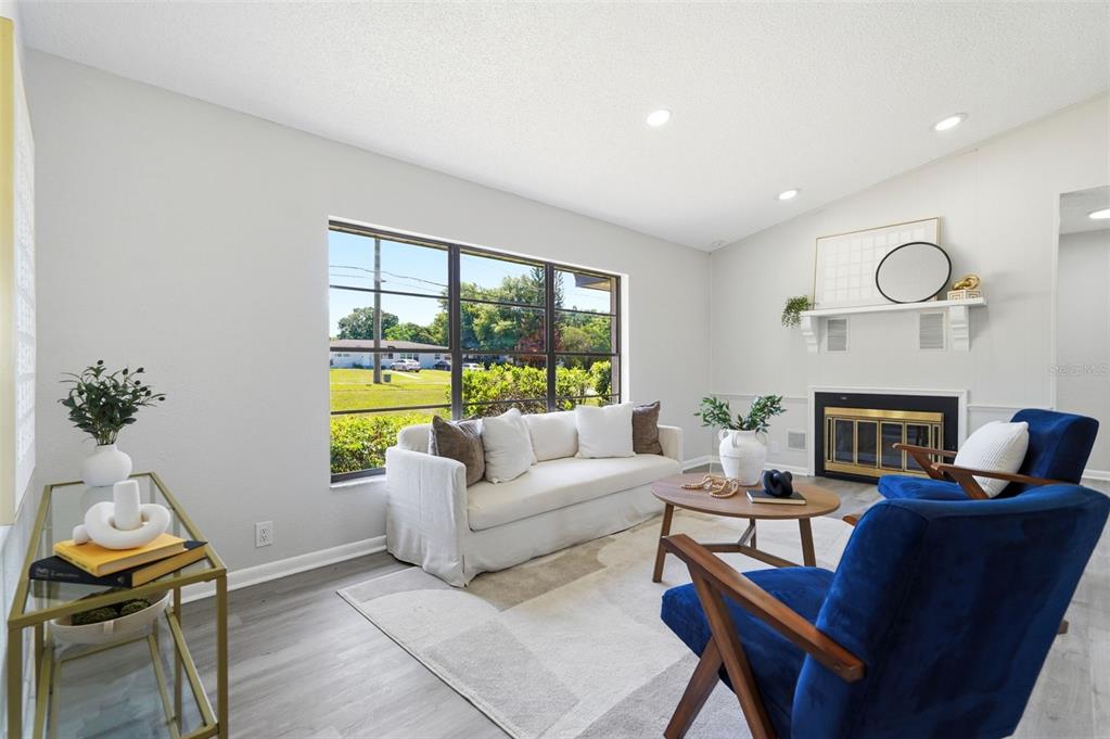 A living room features a white sofa, two blue armchairs, a fireplace, and a large window — 1020 S SCENIC HIGHWAY, LAKE WALES, FL