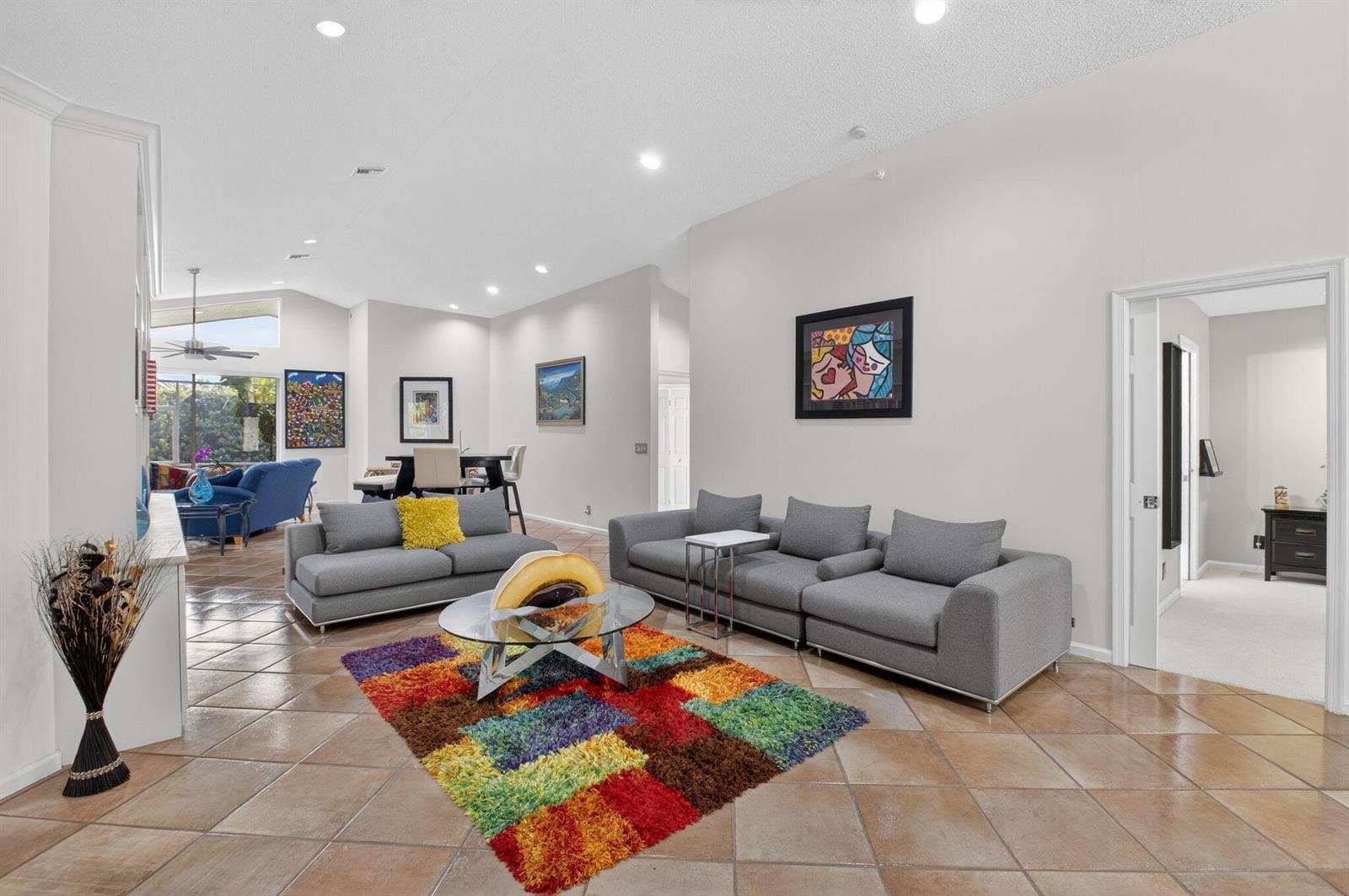 A living room features gray sofas, a colorful shag rug, and tile flooring — 11590 Creekside Drive, Boynton Beach FL 33437, BOYNTON BEACH, FL