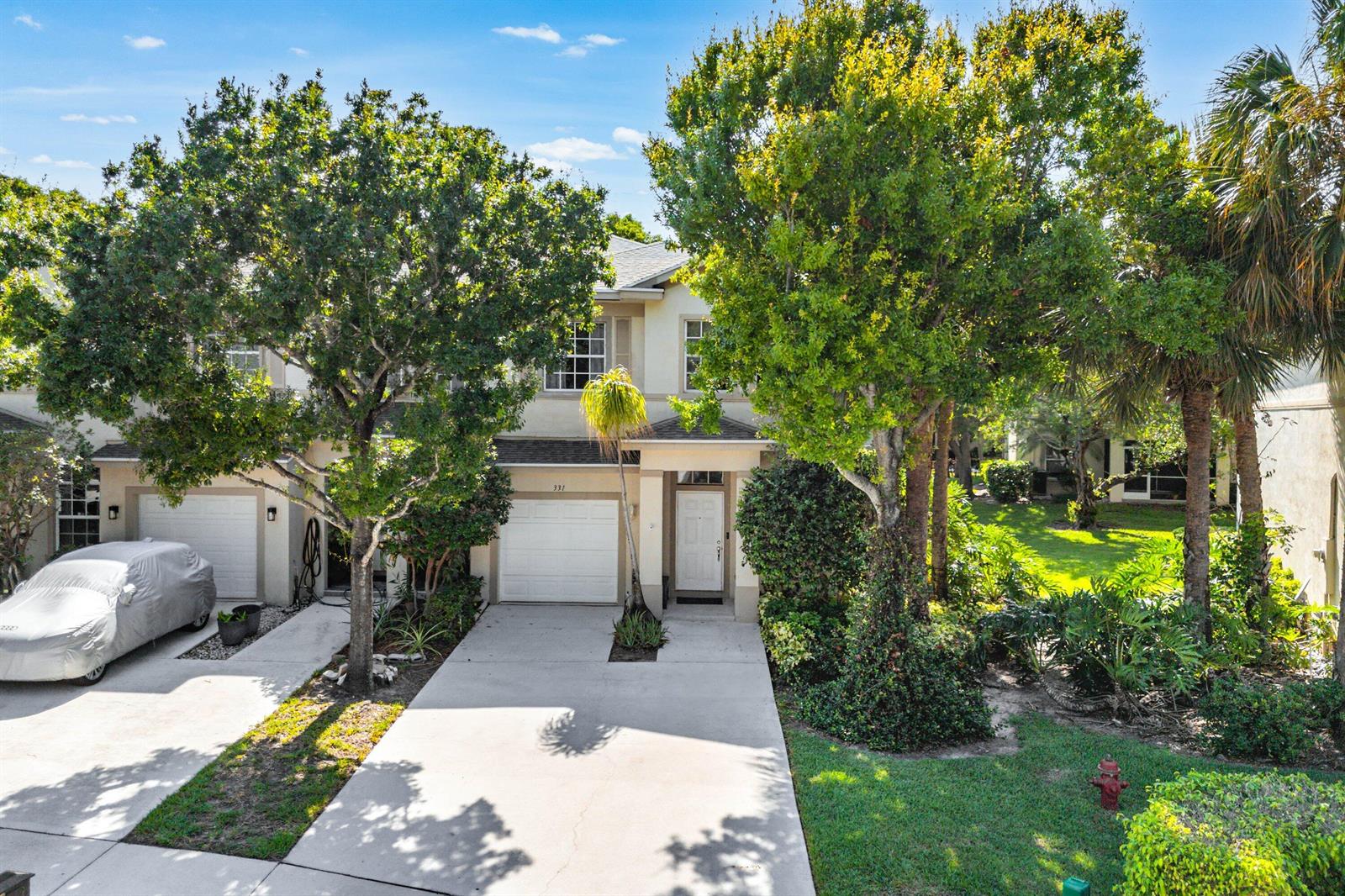 A two-story townhouse with a concrete driveway, two garage doors, and mature trees in front — 331 Spruce Street, Boynton Beach FL 33426, BOYNTON BEACH, FL