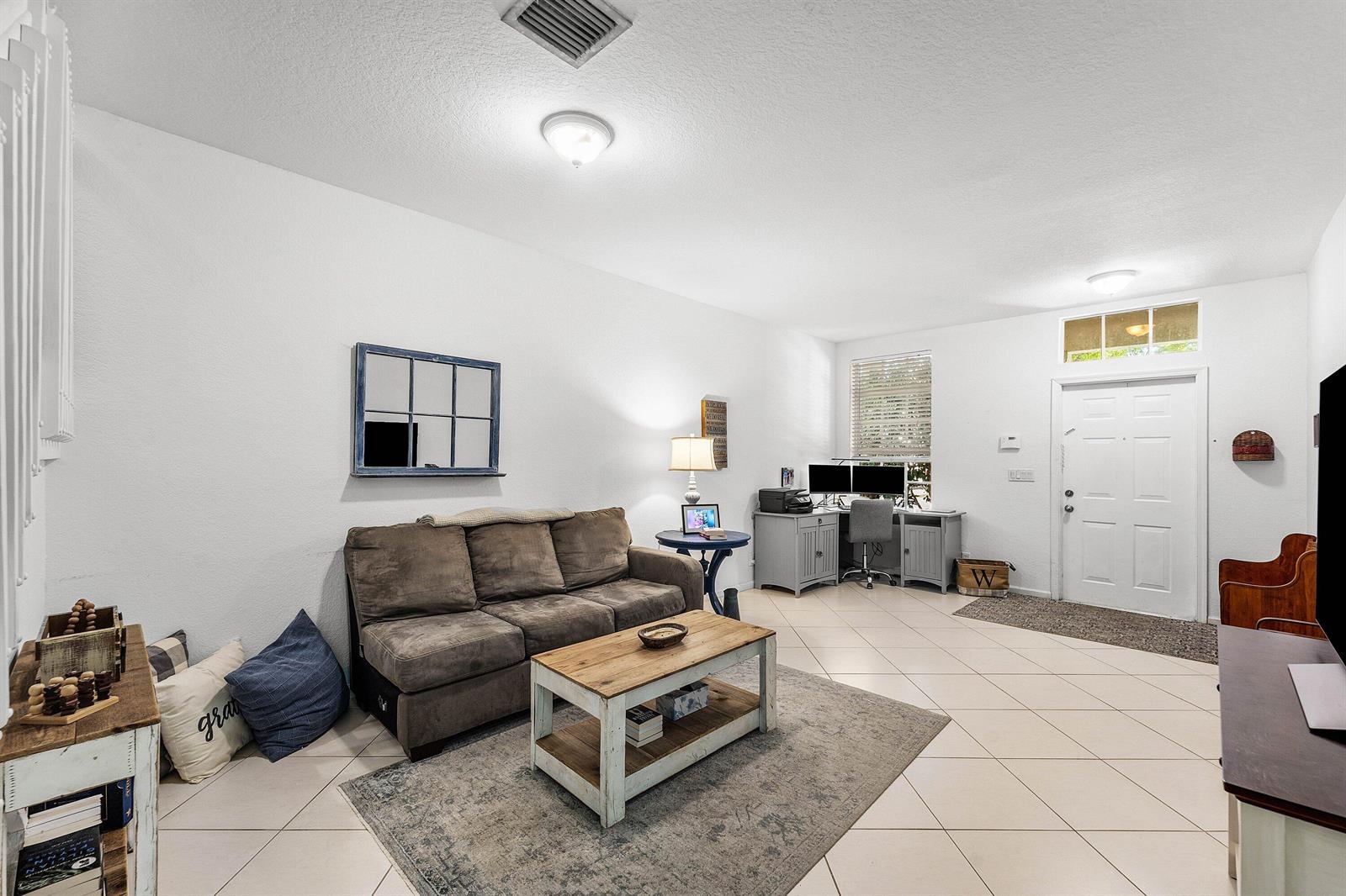 A living room features a brown sofa, coffee table, desk area, and tile flooring — 331 Spruce Street, Boynton Beach FL 33426, BOYNTON BEACH, FL