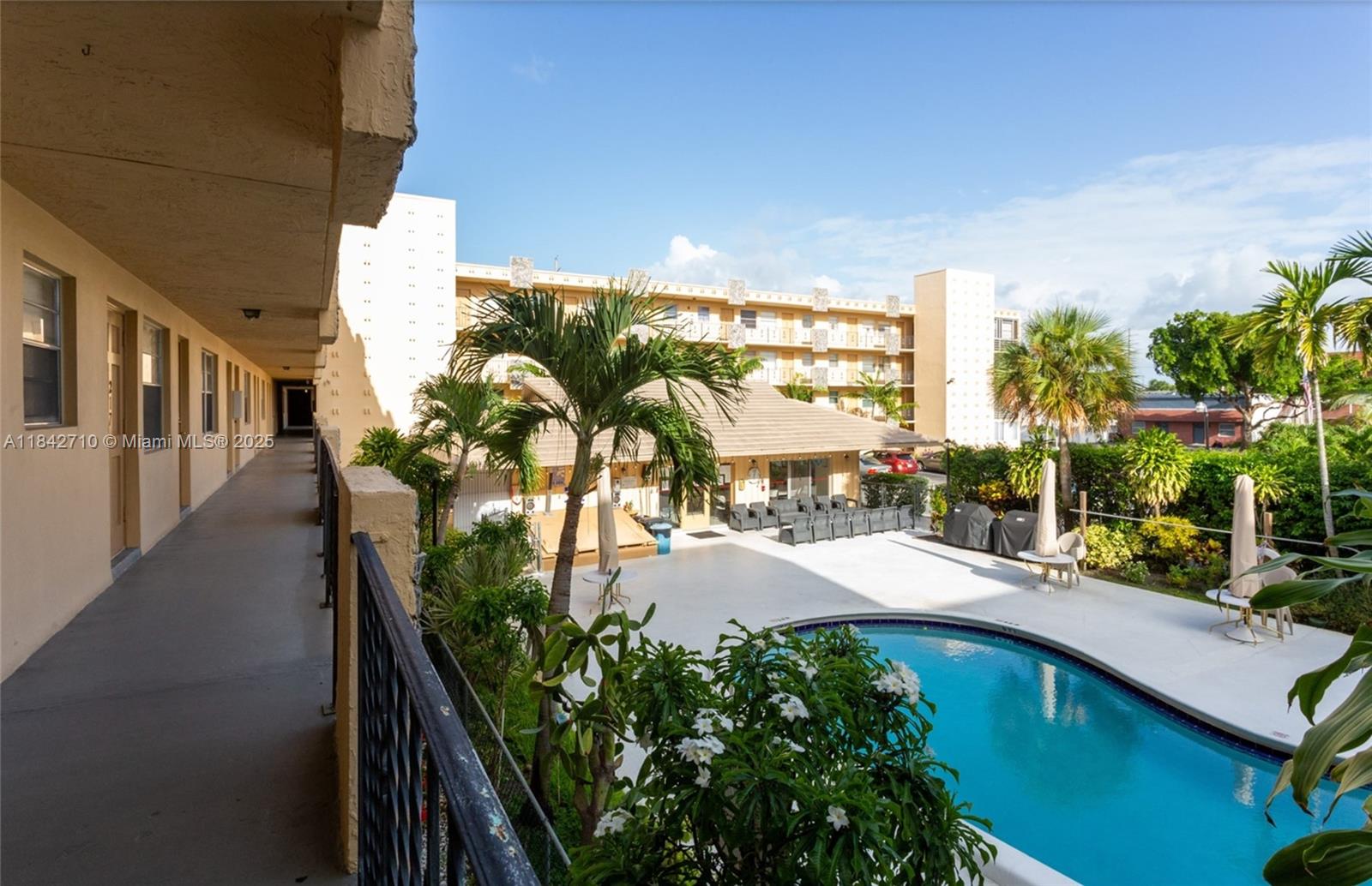 An elevated view of a swimming pool area surrounded by a multi-story apartment building — 2145 Pierce St # 218, Hollywood FL 33020, HOLLYWOOD, FL