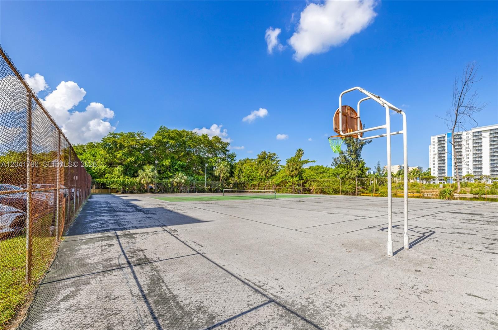 An outdoor basketball court and tennis court are situated on a paved recreational area — 4805 NW 7th St # 15, Miami FL 33126, MIAMI, FL