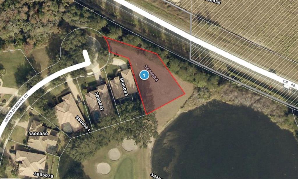 This aerial map shows a vacant residential lot outlined in red next to a lake — 9901 SANTA BARBARA COURT, HOWEY IN THE HILLS, FL