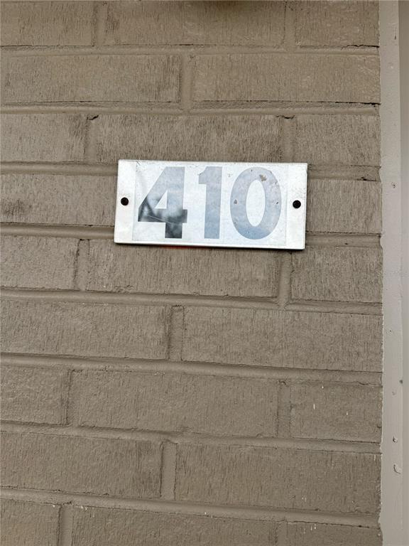 A silver rectangular address plaque with the number 410 is mounted on a brick wall — 800 N FISKE BOULEVARD UNIT 410, COCOA, FL