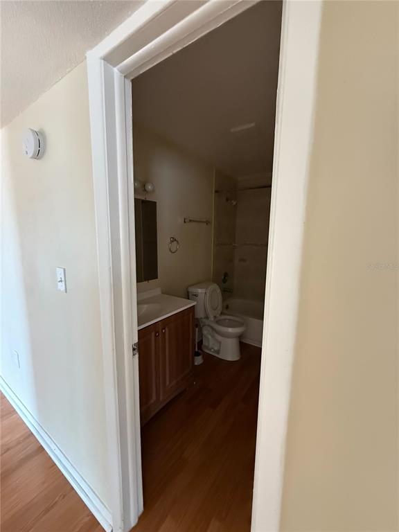 A bathroom with a vanity, toilet, and shower-tub combination viewed through an open doorway — 800 N FISKE BOULEVARD UNIT 410, COCOA, FL