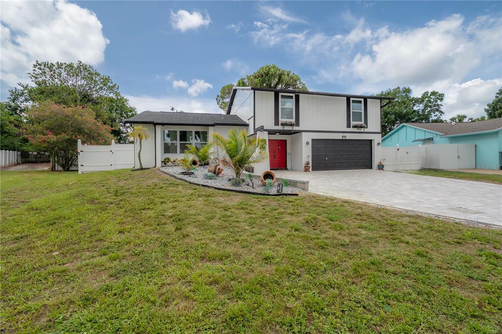 A two-story house with a white exterior, black trim, a red front door, and a driveway — 7312 NOVA CIRCLE, TAMPA, FL