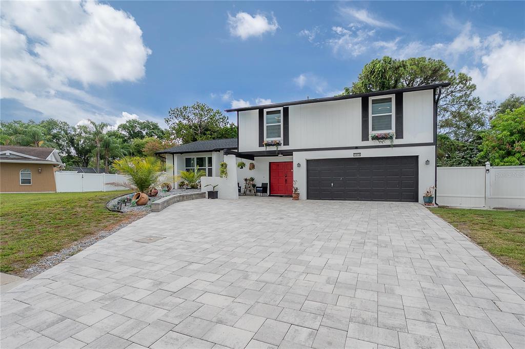 A two-story house with white siding, a red front door, and a paved driveway — 7312 NOVA CIRCLE, TAMPA, FL