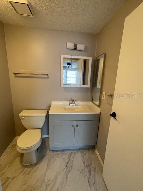 A bathroom features a white vanity, a toilet, a medicine cabinet, and light-colored tile flooring — 124 LOBLOLLY COURT UNIT D, OLDSMAR, FL