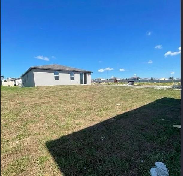 A view of the side and back of a single-story house with a large yard — 1505 CONGAREE STREET, DAVENPORT, FL