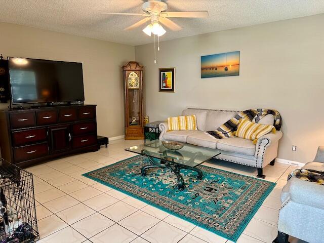 A living room features a large television, a grandfather clock, and a patterned area rug — 769 Burgundy Q, Delray Beach FL 33484, DELRAY BEACH, FL