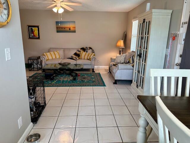 A living room with tile floors, a sofa, a coffee table, and a white cabinet — 769 Burgundy Q, Delray Beach FL 33484, DELRAY BEACH, FL