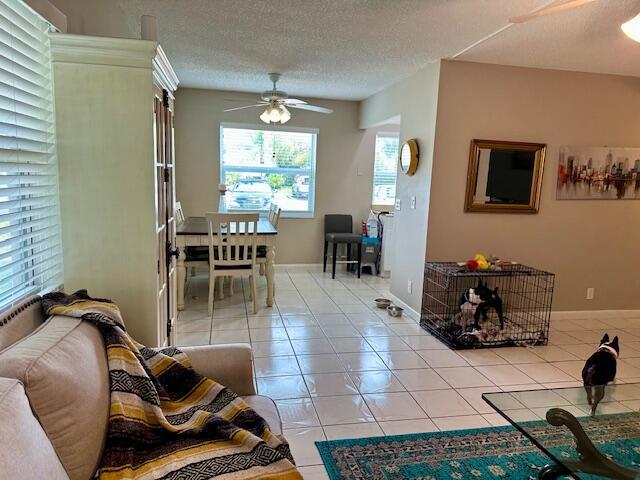 A living and dining area features tiled floors, a ceiling fan, and a dog crate — 769 Burgundy Q, Delray Beach FL 33484, DELRAY BEACH, FL