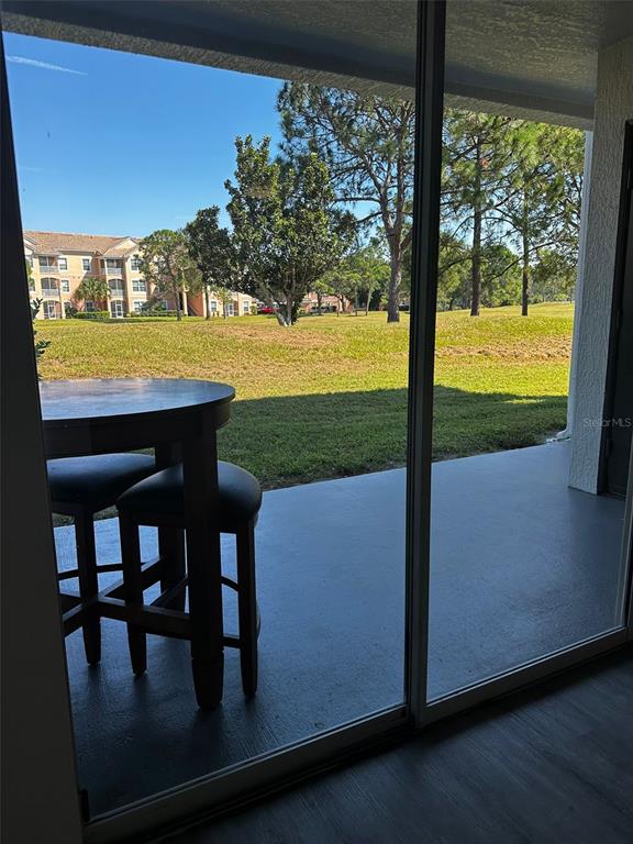 A view from inside looking out through a sliding glass door onto a covered patio — 14013 FAIRWAY ISLAND DRIVE UNIT 415, ORLANDO, FL