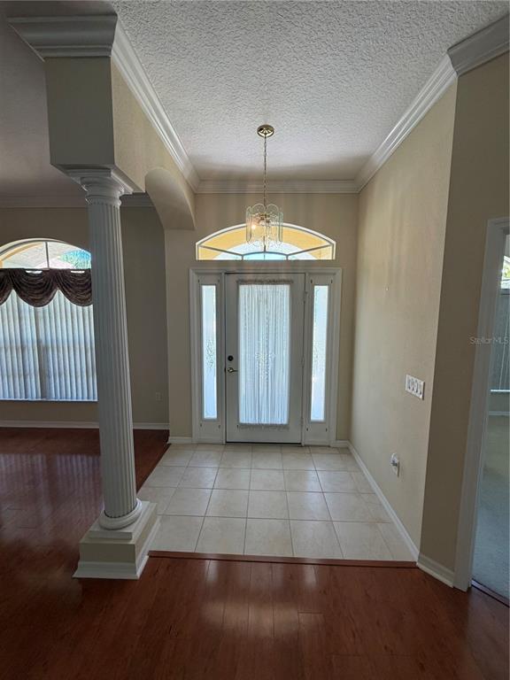 An entryway features a tiled floor, a white front door with sidelights, and a decorative column — 11855 TEE TIME CIRCLE, NEW PORT RICHEY, FL