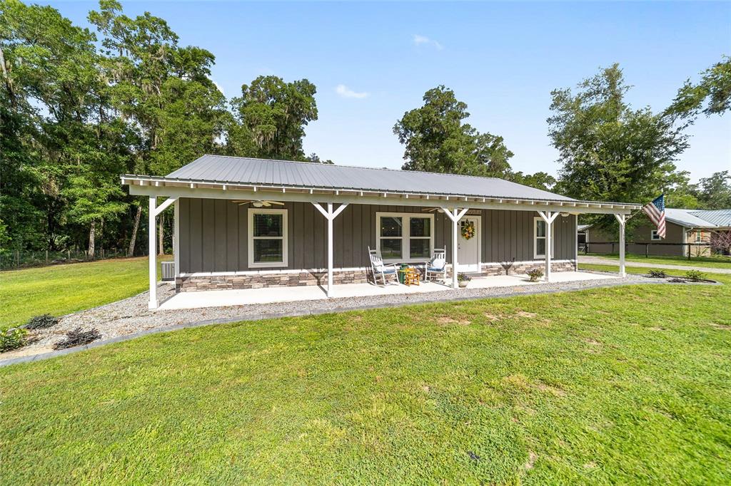 A gray, single-story house with a metal roof and a covered front porch — 14366 NE 42ND TERRACE, ANTHONY, FL