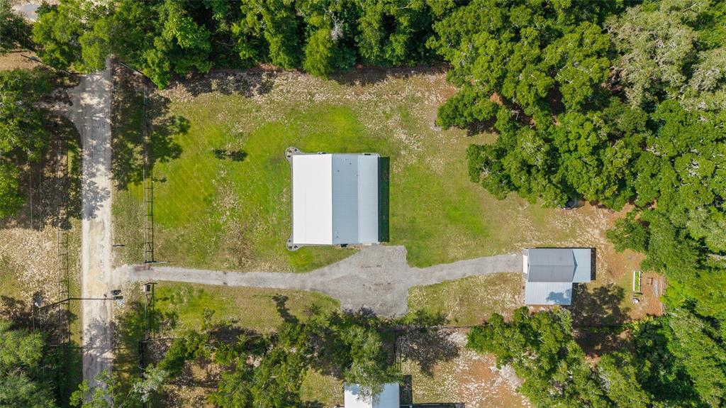 An aerial view shows a rectangular metal building and a smaller structure on a grassy lot — 14366 NE 42ND TERRACE, ANTHONY, FL