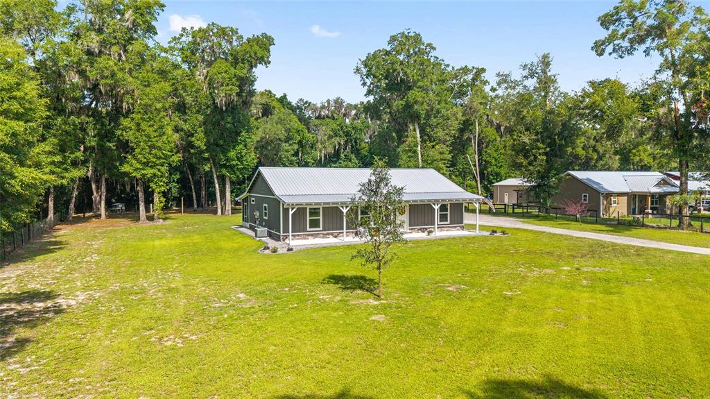 An exterior view of a single-story house with a metal roof and a front porch — 14366 NE 42ND TERRACE, ANTHONY, FL