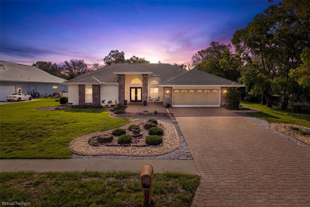 A single-story house with a brick facade, a paved driveway, and a landscaped front yard — 18822 MAJESTIC OAK COURT, HUDSON, FL