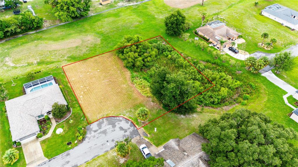 An aerial view shows a vacant, partially wooded residential lot outlined in red — 5413 BOXTREE CT, DADE CITY, FL