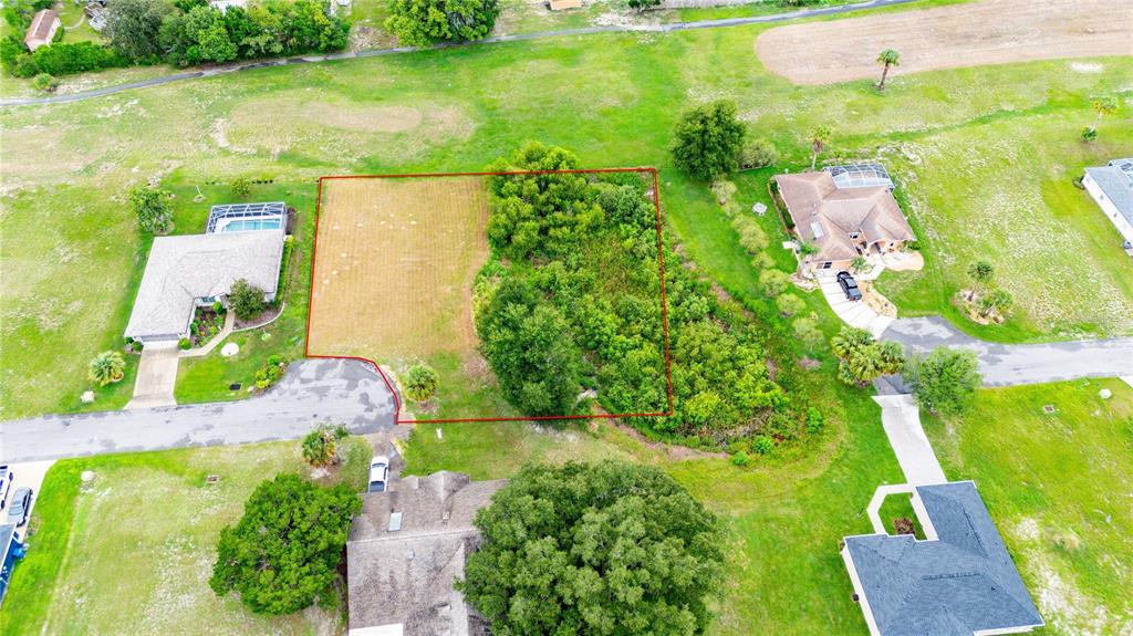An aerial view shows a vacant, partially wooded residential lot outlined in red — 5413 BOXTREE CT, DADE CITY, FL