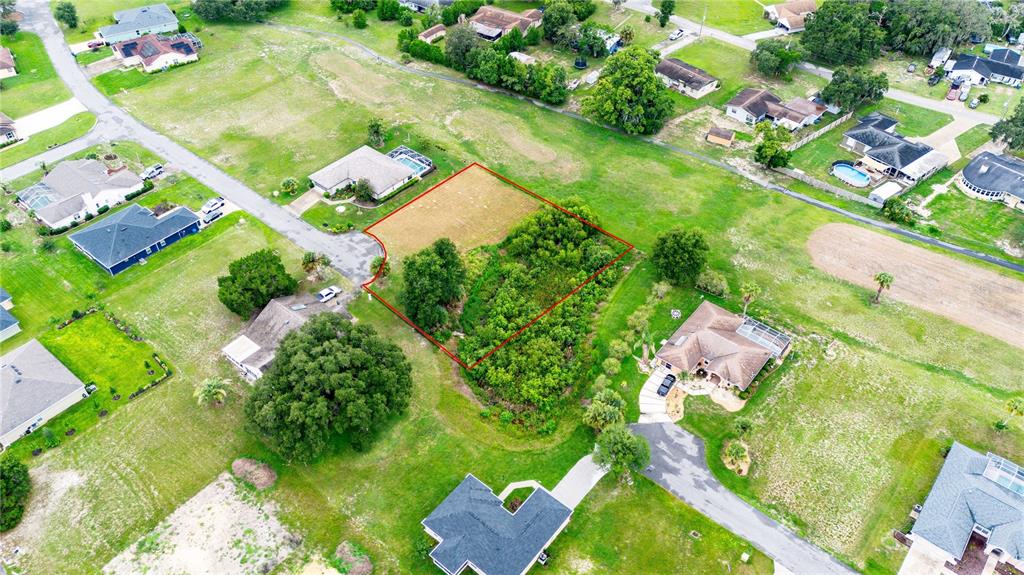 An aerial view shows a vacant, partially wooded residential lot outlined in red — 5413 BOXTREE CT, DADE CITY, FL