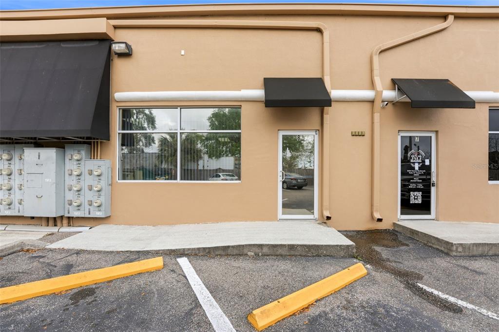 The exterior of a commercial building features two glass entry doors and a large window — 5404 HOOVER BOULEVARD UNIT 8, TAMPA, FL