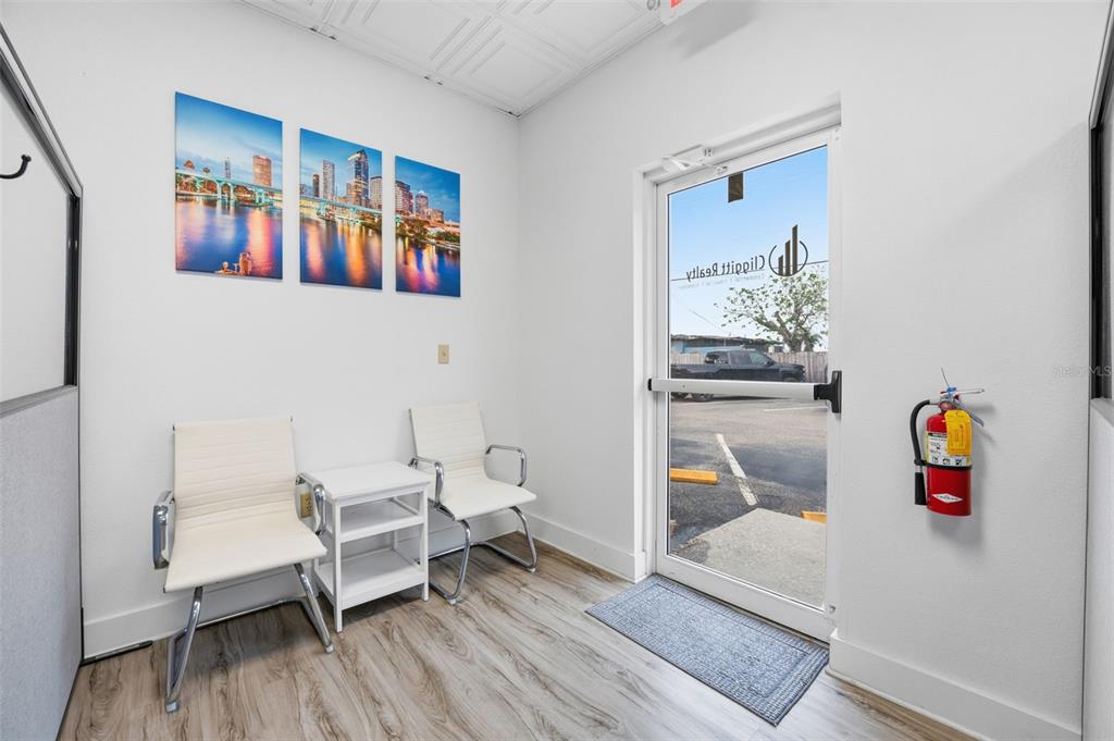 A small office waiting area features two white chairs, a side table, and a glass door — 5404 HOOVER BOULEVARD UNIT 8, TAMPA, FL
