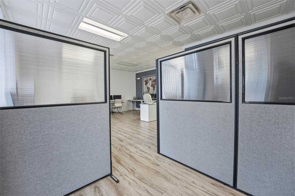 An office space features grey fabric partitions, wood-look flooring, and a white coffered ceiling — 5404 HOOVER BOULEVARD UNIT 8, TAMPA, FL
