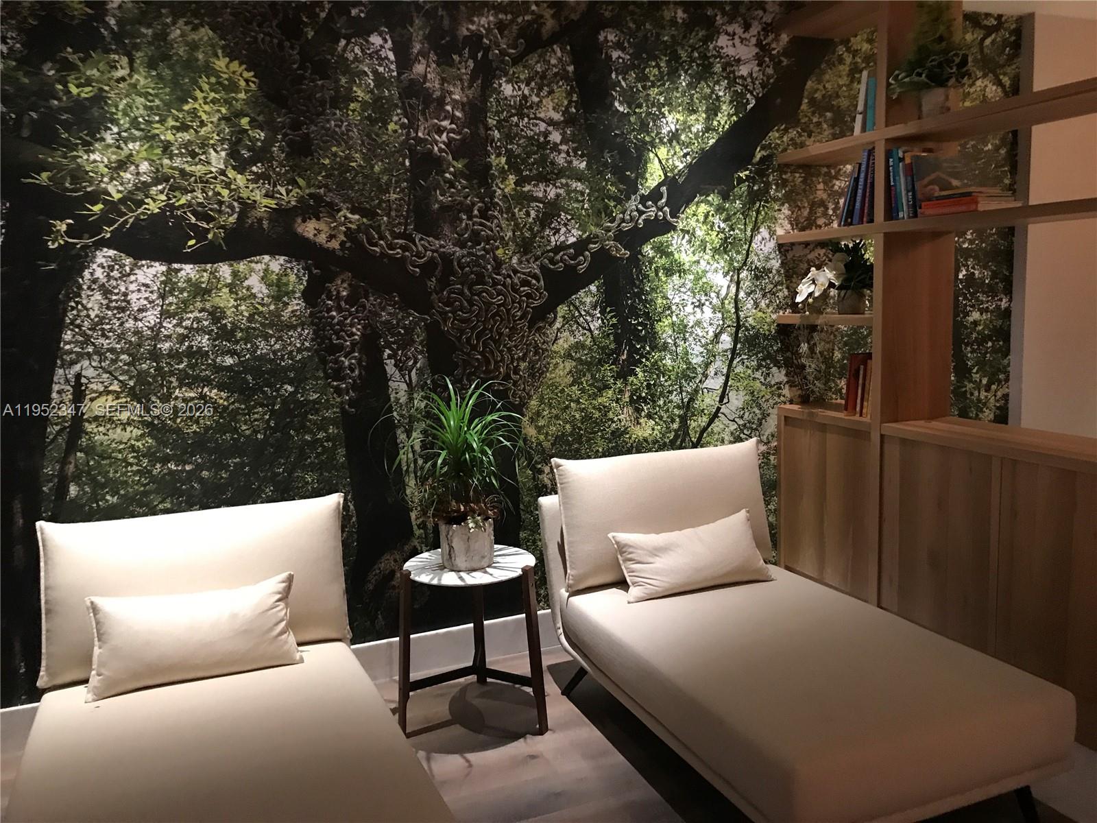 Two lounge chairs sit before a forest mural next to a wooden bookshelf — 1010 BRICKELL AVE # 2110, Miami FL 33131, MIAMI, FL