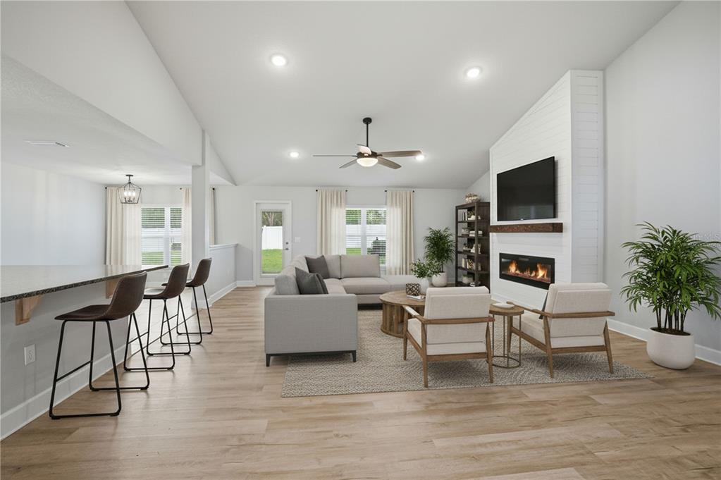 This is a digital rendering of a modern open-concept living room with a fireplace — 12847 HILARY STREET, SPRING HILL, FL