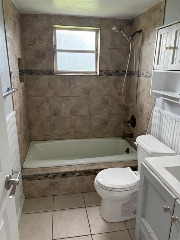 A bathroom features a tiled tub surround, a window, a toilet, and a vanity cabinet — 1423 NE LIVINGSTON STREET, ARCADIA, FL