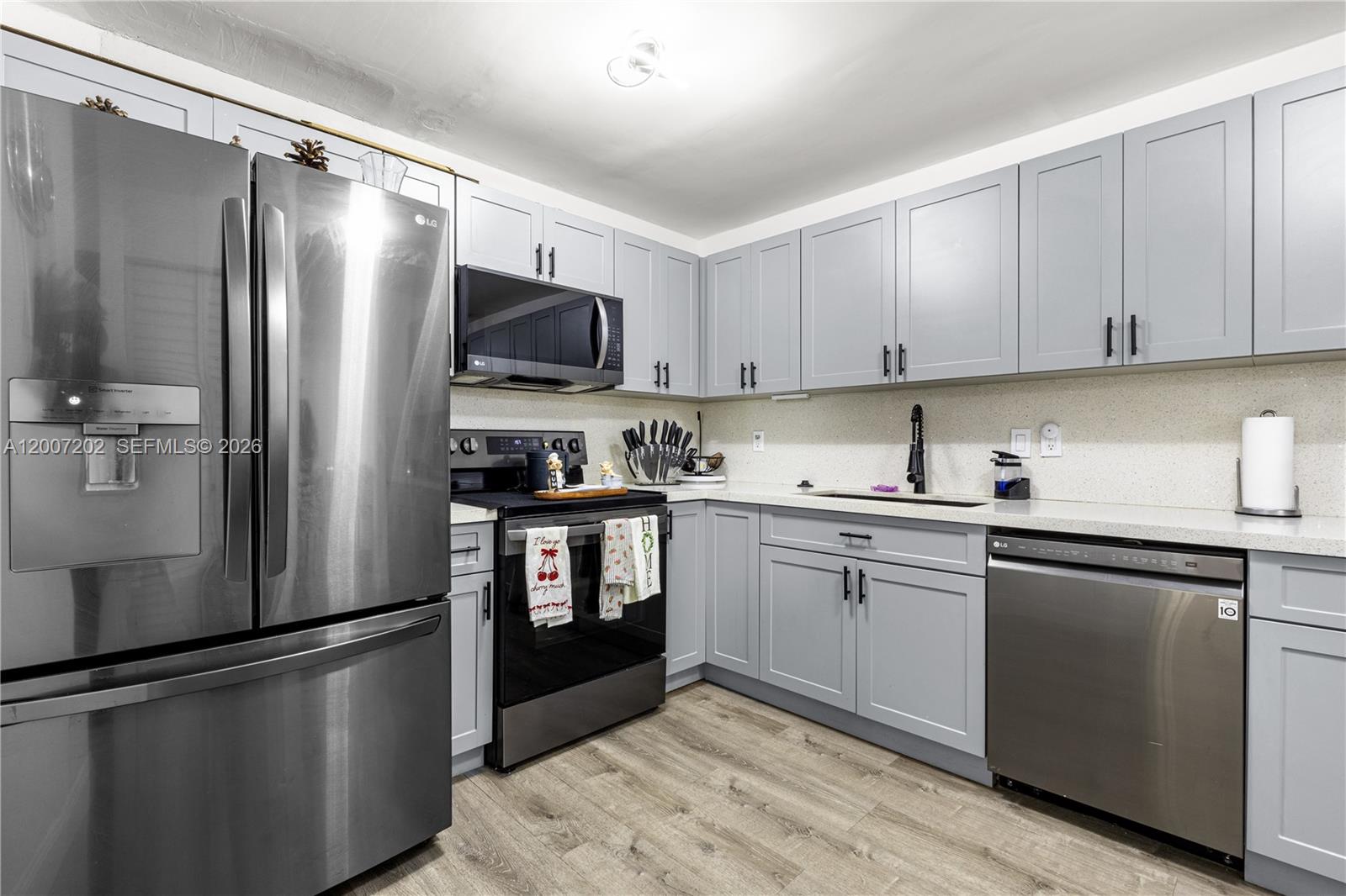 A kitchen features gray shaker cabinets, stainless steel appliances, and light-colored countertops — 203 NE 12th Ave # 203, Homestead FL 33030, HOMESTEAD, FL