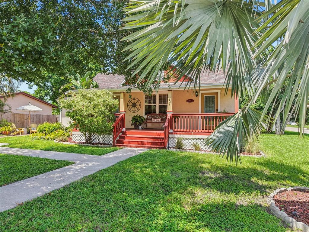 A single-story house with a red porch and steps sits behind a large palm tree — 501 32ND AVENUE N, ST PETERSBURG, FL