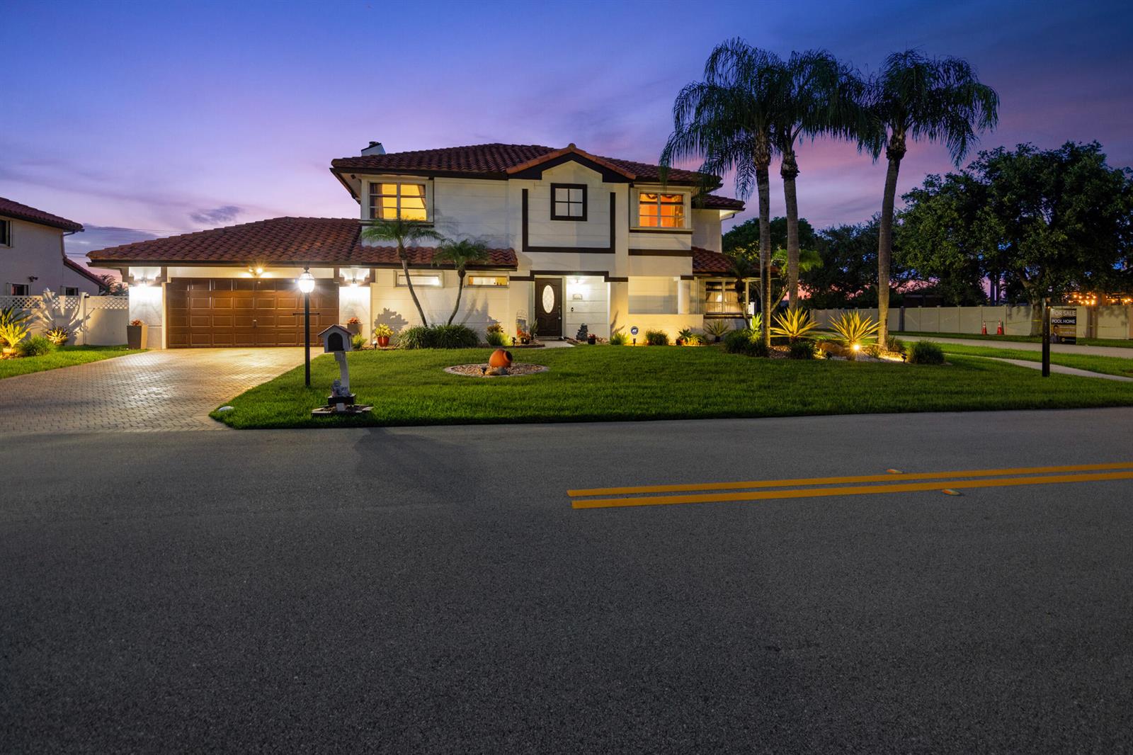 A two-story house with a tile roof and a paved driveway at dusk — 6431 Olde Moat Way, Davie FL 33331, DAVIE, FL