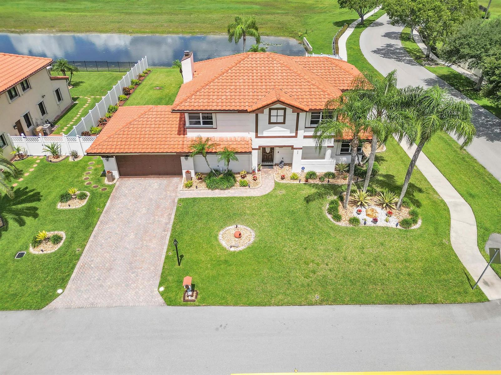 An aerial view shows a two-story house with a terracotta tile roof and paved driveway — 6431 Olde Moat Way, Davie FL 33331, DAVIE, FL